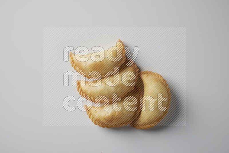 Four fried sambosa from a top angle on a white background