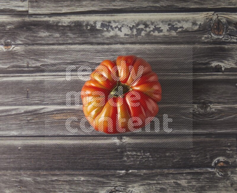 Single Tipview Heirloom Tomato on grey wooden background