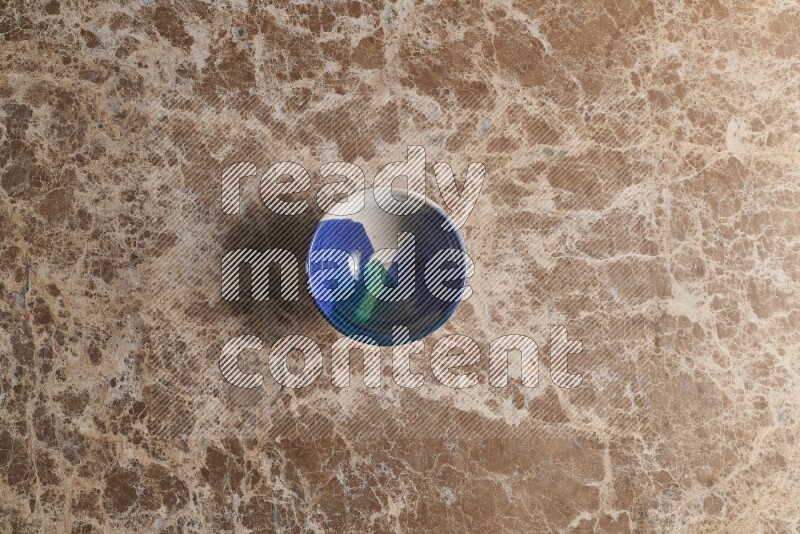 A multicolored pottery bowl on beige marble background