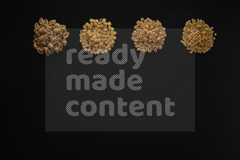 Different pasta types in 4 bunches on black background