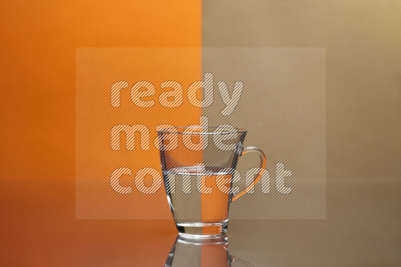 The image features a clear glassware filled with water, set against orange and beige background
