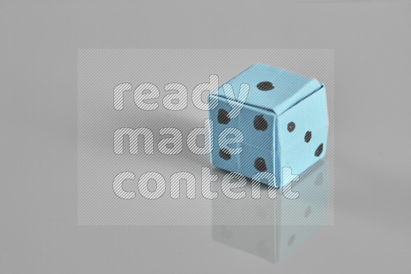 Origami dice on grey background