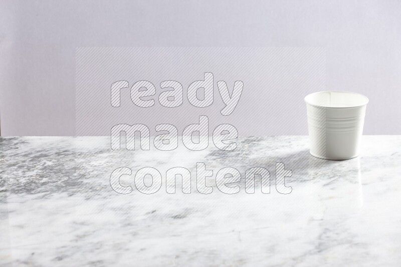 An empty white plant pot on grey marble background