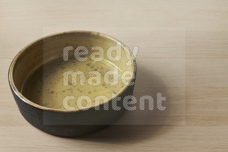 A multicolored pottery oven plate on light wooden background
