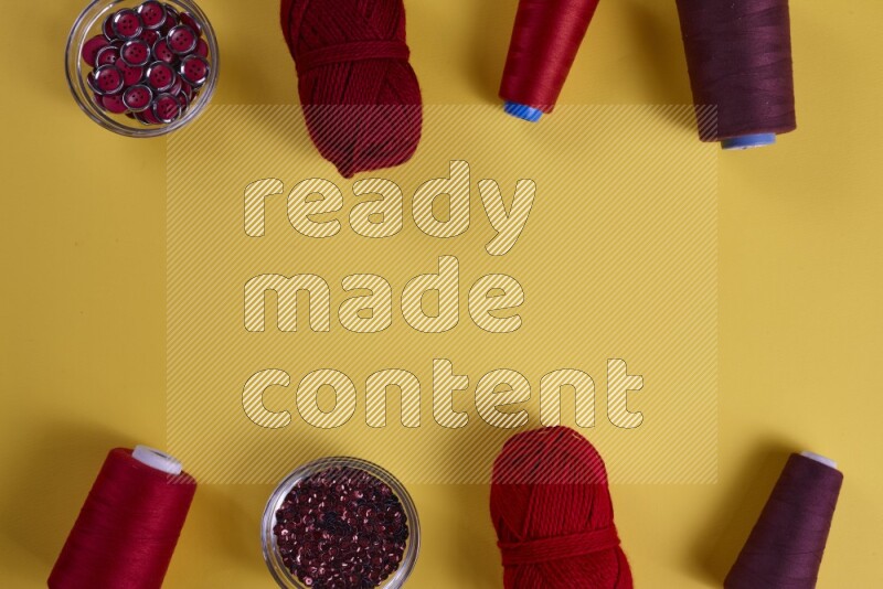 مجموعة من أدوات الخياطة والتفصيل حمراء اللون على خلفية صفراء