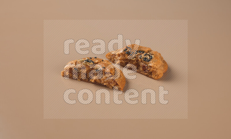 a Hasawi cookie field of date and herbs with another one cut in half on a brown background