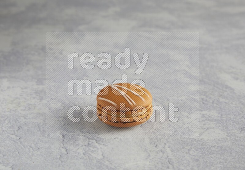 45º Shot of Brown Irish Cream macaron on white marble background
