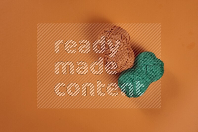 مجموعة من أدوات الخياطة والتفصيل خضراء وبرتقالية اللون على خلفية برتقالية