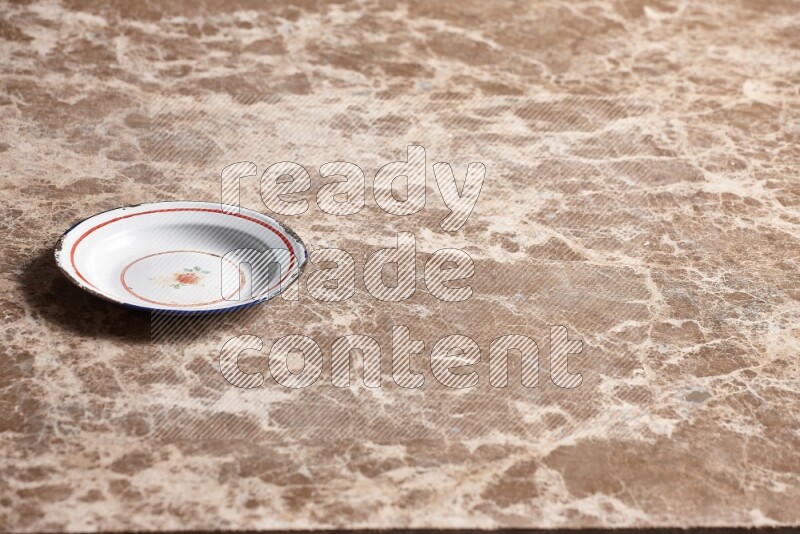 A vintage metal plate on beige marble background