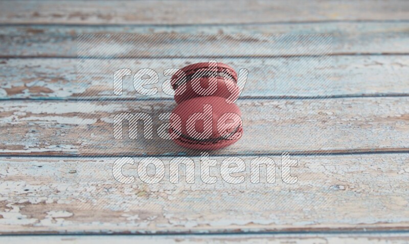 45º Shot of two Red Cherry macarons on light blue wooden background