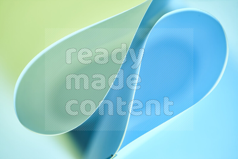 An abstract art of paper folded into smooth curves in green and blue gradients