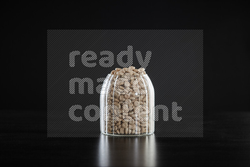 Lupin Beans in a glass jar on black background