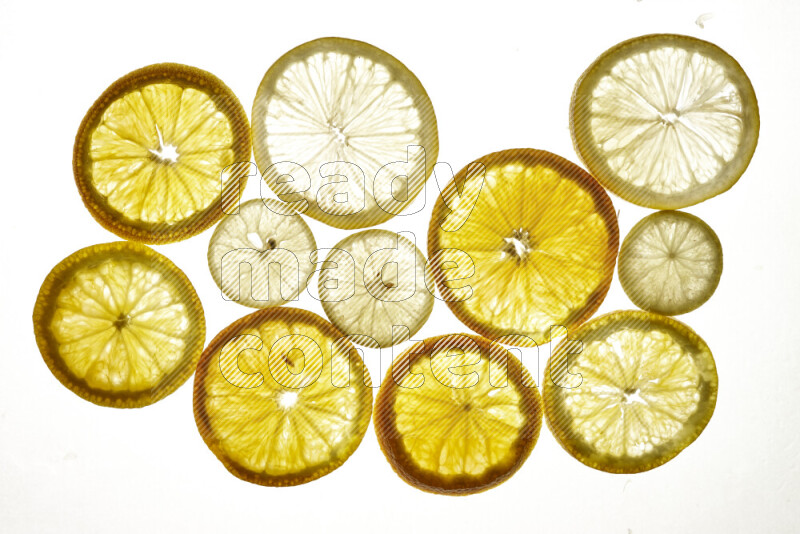 Mixed vegetables and fruits slices on illuminated white background