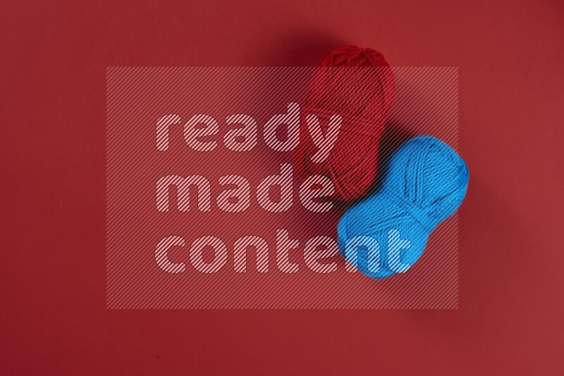 مجموعة من أدوات الخياطة والتفصيل زرقاء وحمراء اللون على خلفية حمراء