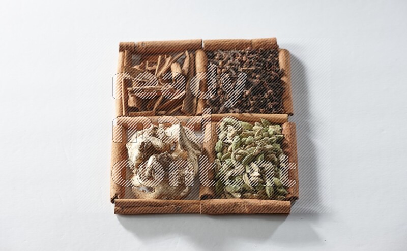 4 squares of cinnamon sticks full of cardamom, cinnamon, cloves and dried ginger on white flooring