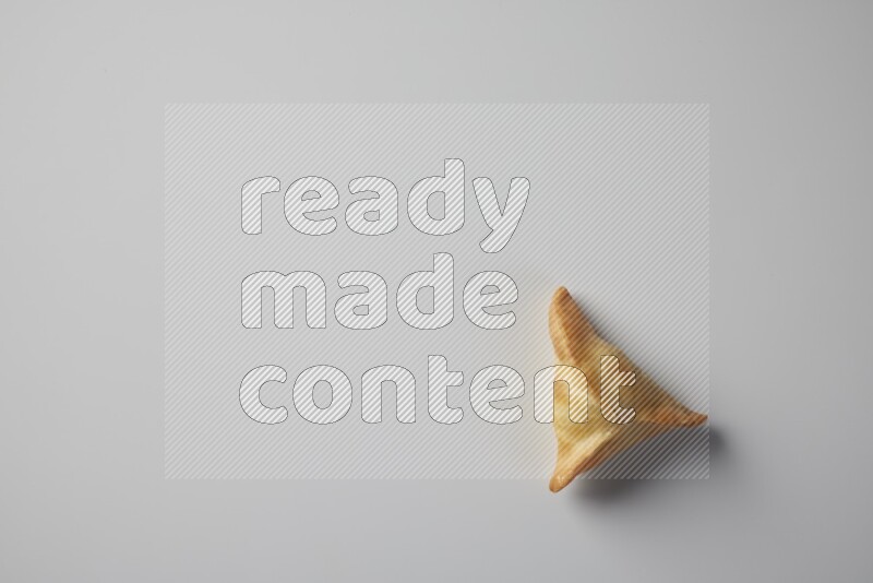 One fried sambosa from a top angle on a white background