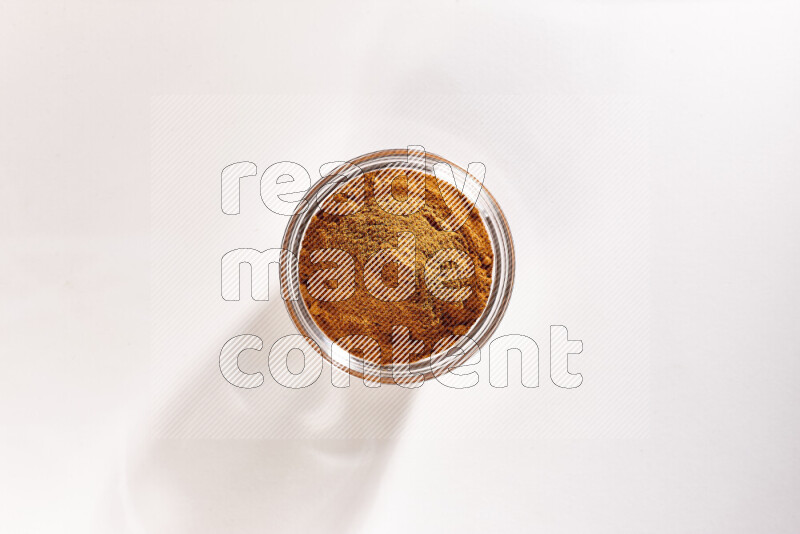 A glass bowl full of ground paprika powder on white background