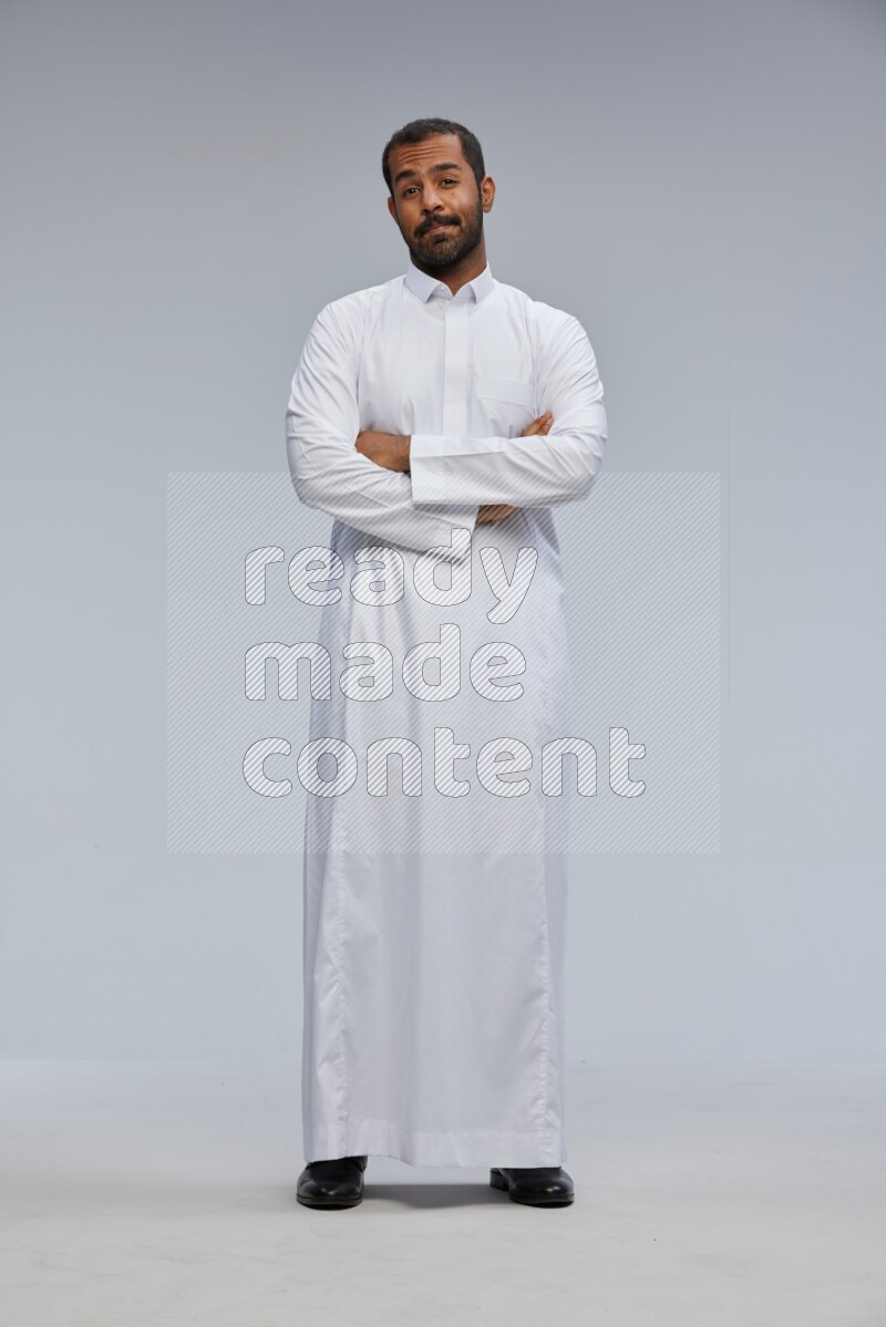 Saudi man wearing Thob standing with crossed arms on Gray background