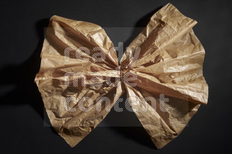 Crumpled craft paper on black background