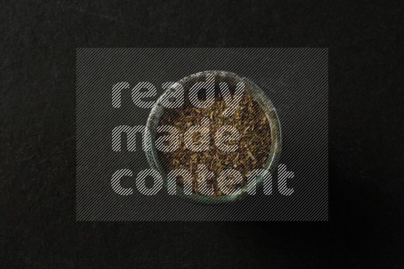 multi color round sauce bowl filled with herbs on grey textured countertop