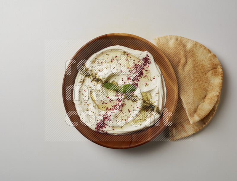 Lebnah garnished with  zattar , sumak & mint in a wooden plate on a white background