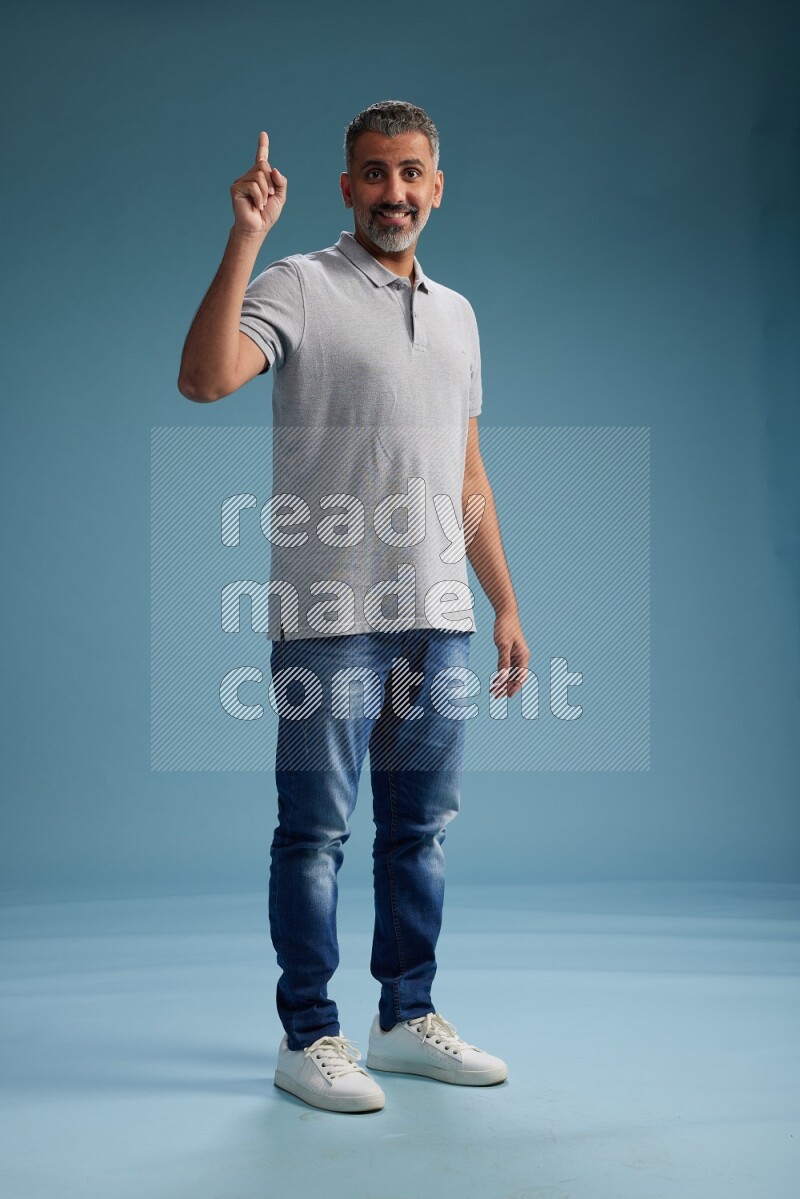 Man Standing Interacting with the camera on blue background