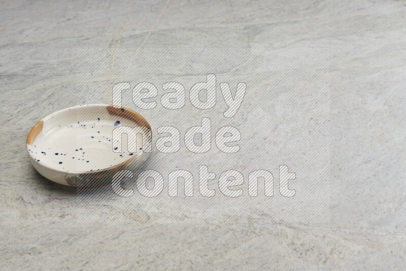 A multicolored pottery bowl on grey marble background