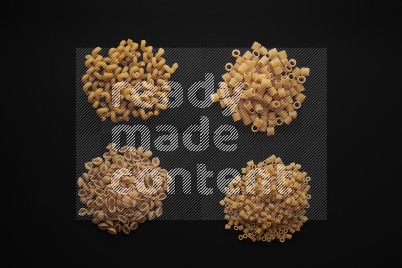 Different pasta types in bunches on black background