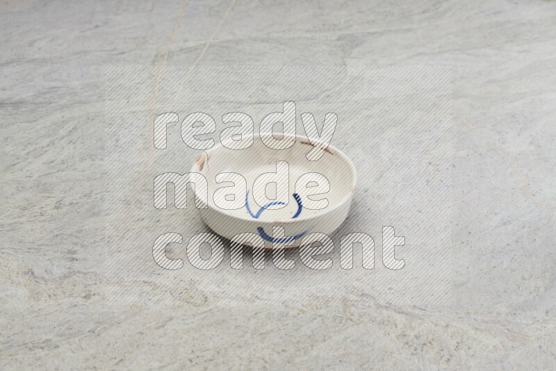 A multicolored pottery bowl on grey marble background