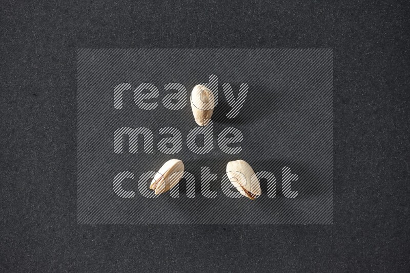 3 pistachios on a black background in different angles
