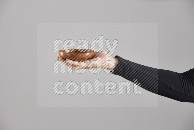 A woman in black abaya holding different wooden essentials in different positions