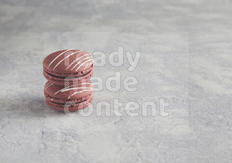 45º Shot of two Red Poppy Flower macarons on white  marble background