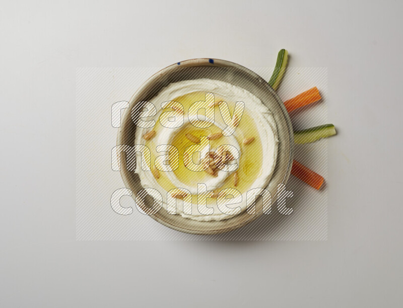 Lebnah garnished with pine nuts in a grey pottery plate on a white background