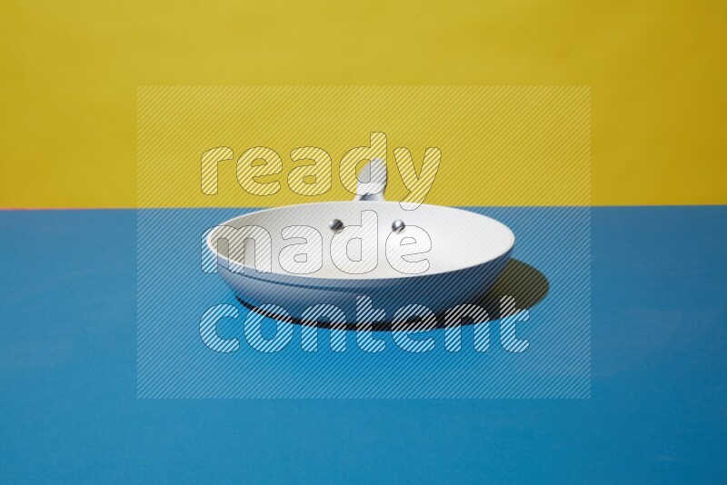 white pan on yellow and Blue background