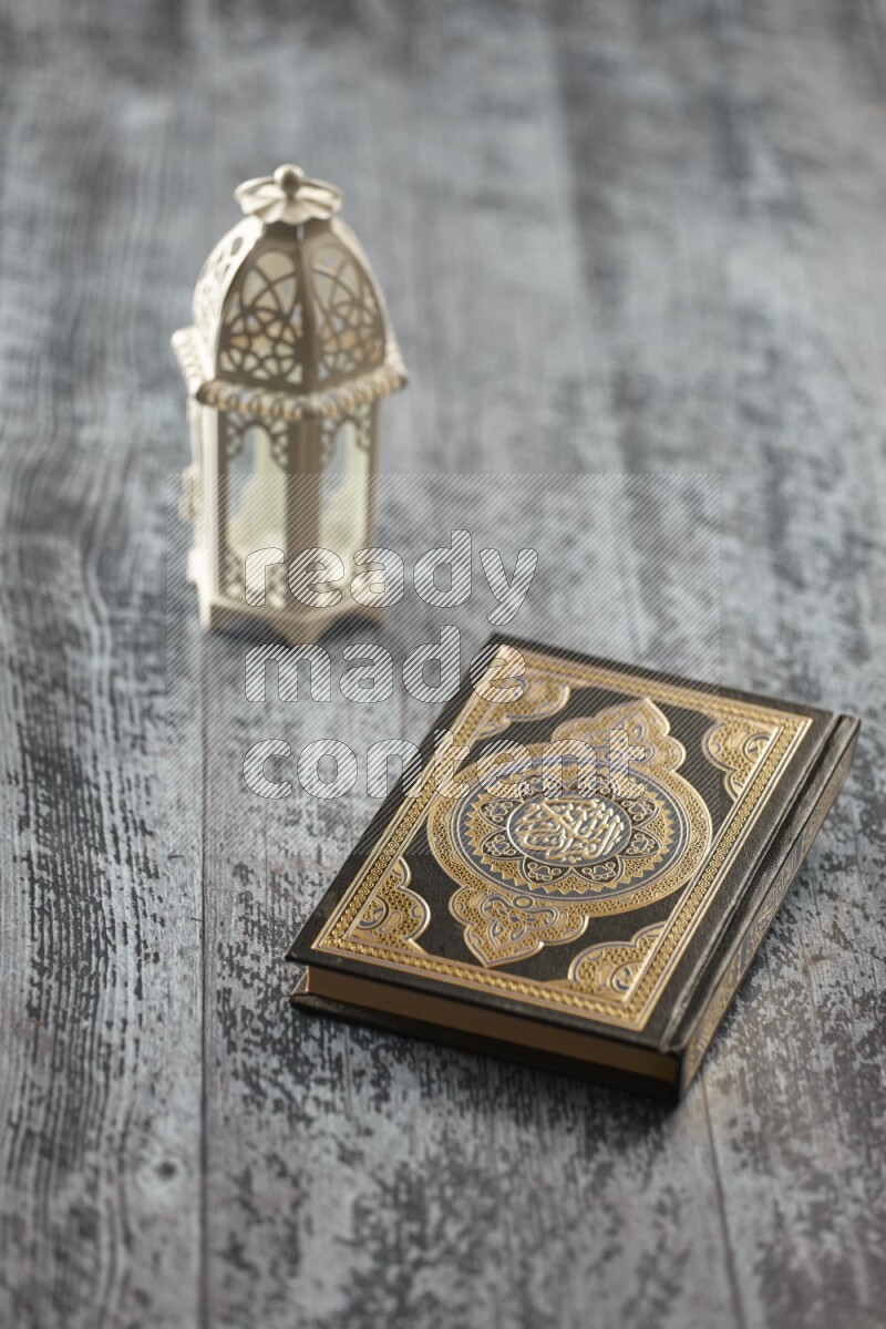 A white lantern with different drinks, dates, nuts, prayer beads and quran on grey wooden background