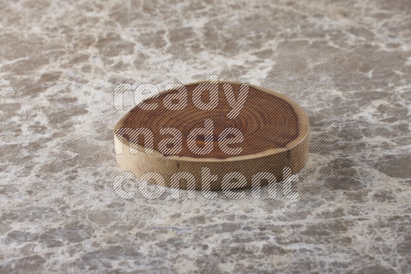 A circular wooden slab with natural textures on beige marble background
