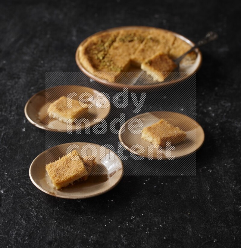 كنافة في أطباق مختلفه علي خلفية سوداء خشبية