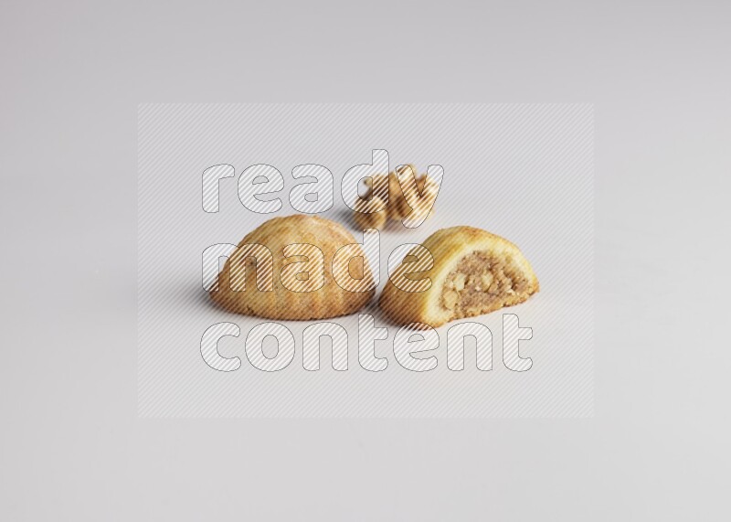 Two Pieces of Maamoul filled with walnut paste  one of them is cut direct on white background