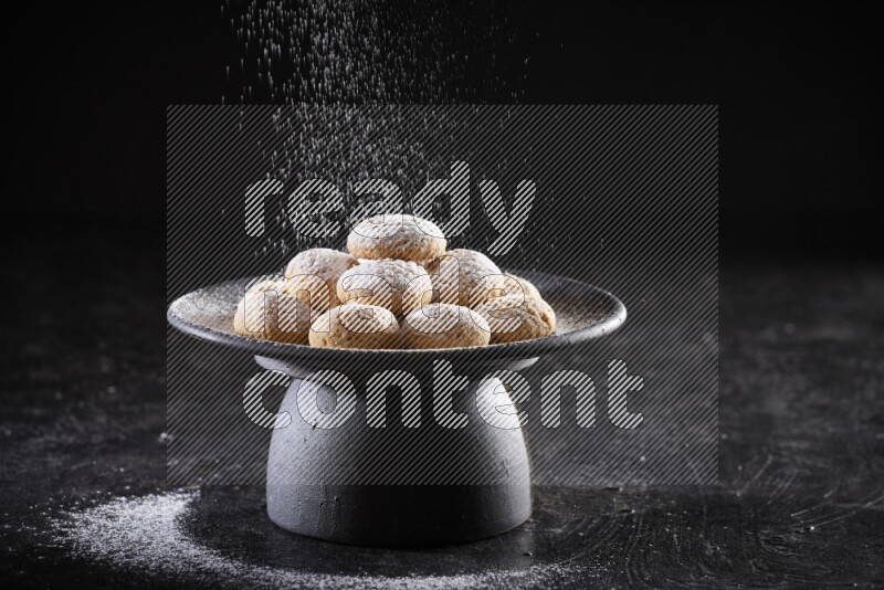 Kahk on a serving plate on a black background