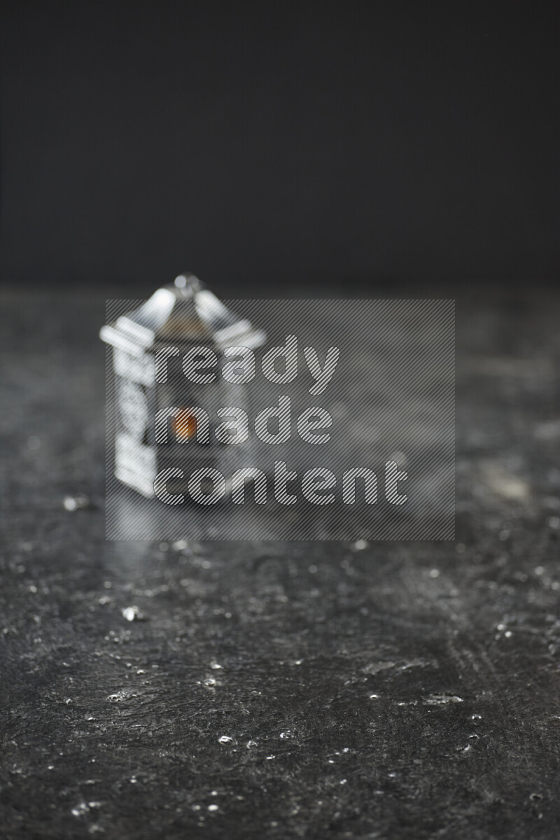 A lantern placed on a textured black background