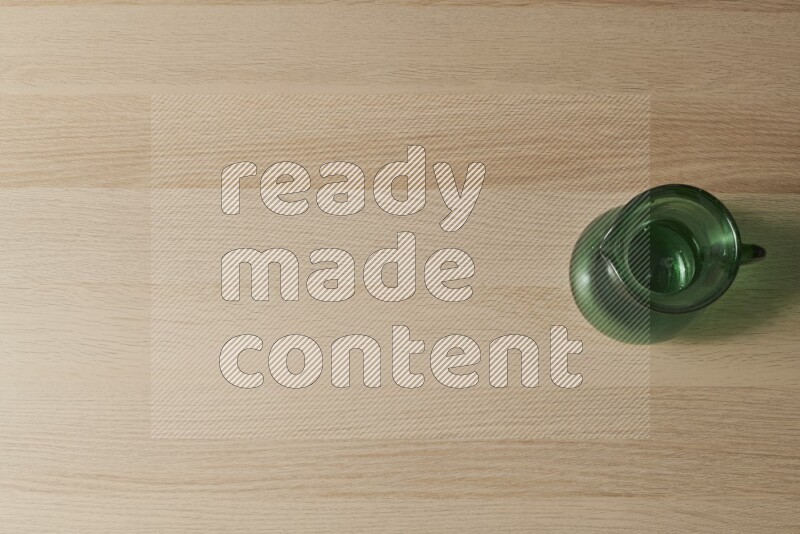 إبريق زجاجي فارغ على خلفية خشبية فاتحة