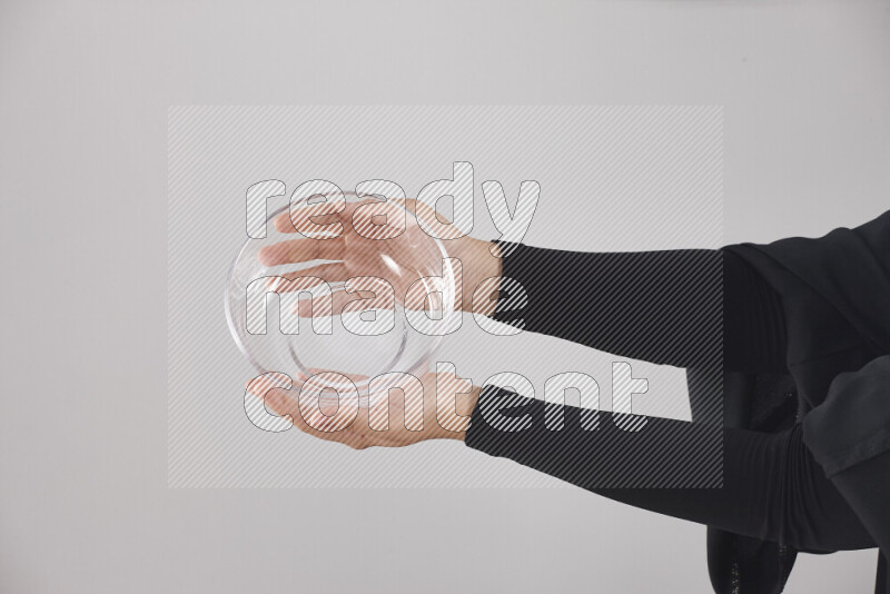 امرأة ترتدي عباءة سوداء تحمل أدوات زجاجية مختلفة في أوضاع متعددة