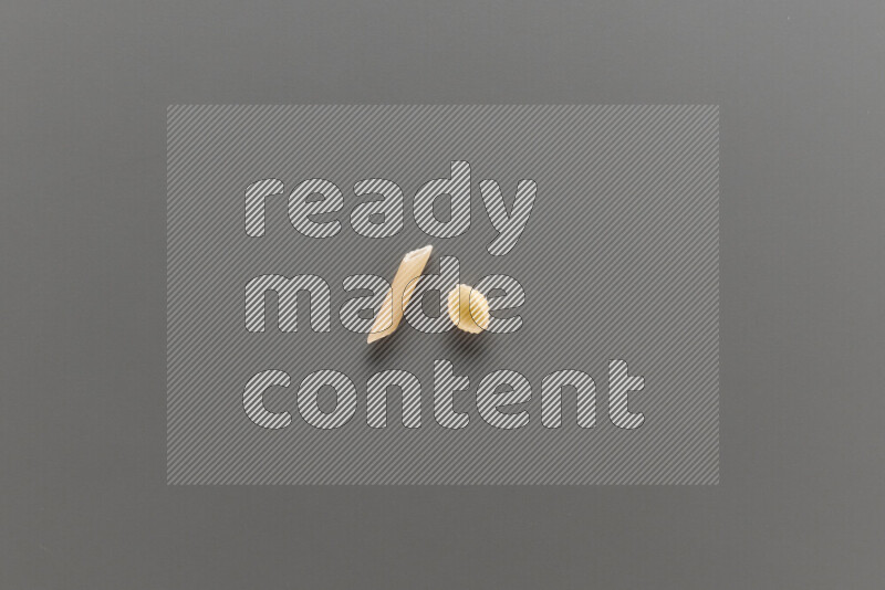 معكرونة فرن صغيرة مع أنواع أخري من المعكرونة علي خلفية رمادية