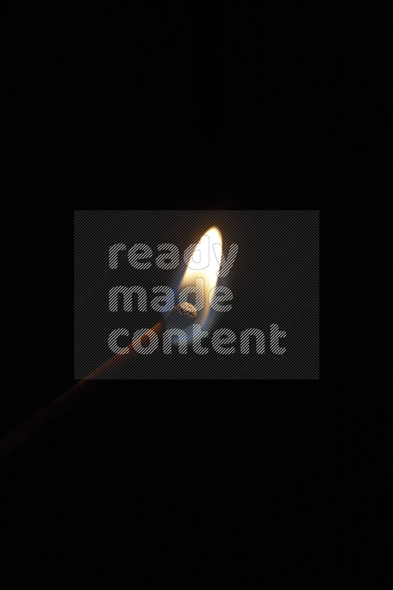 A burning matchstick isolated on dark backdrop