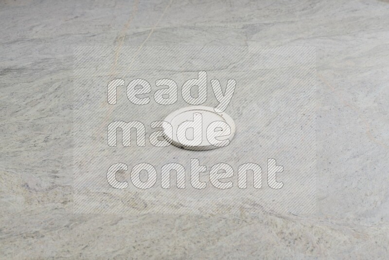 A white pottery bowl's lid on grey marble background