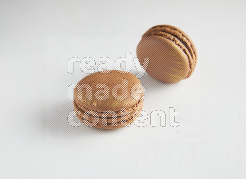 45º Shot of two Brown Coffee macarons on white background