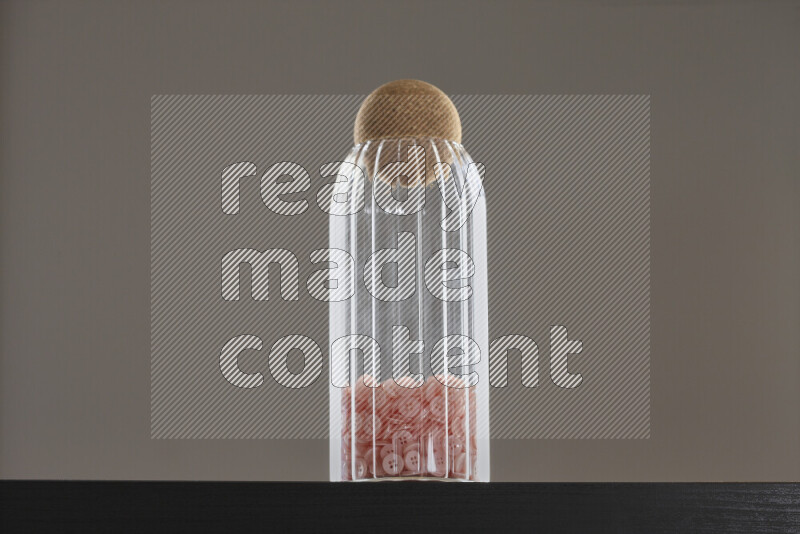 أزرار متنوعة في وعاء زجاجي علي خلفية سوداء