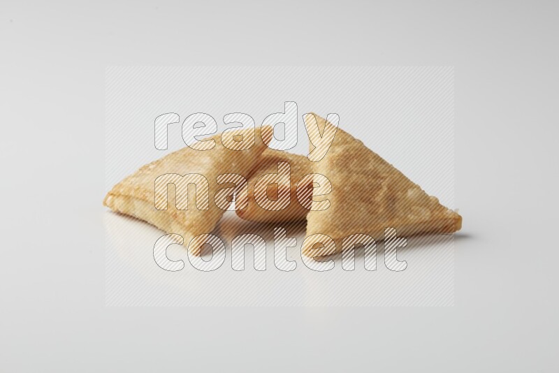 Three fried sambosas on a white background