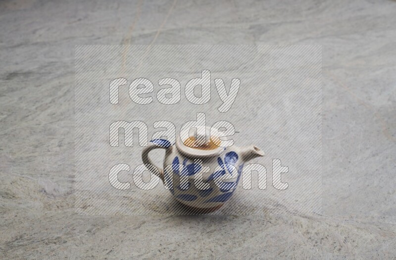 A pottery teapot on grey marble background