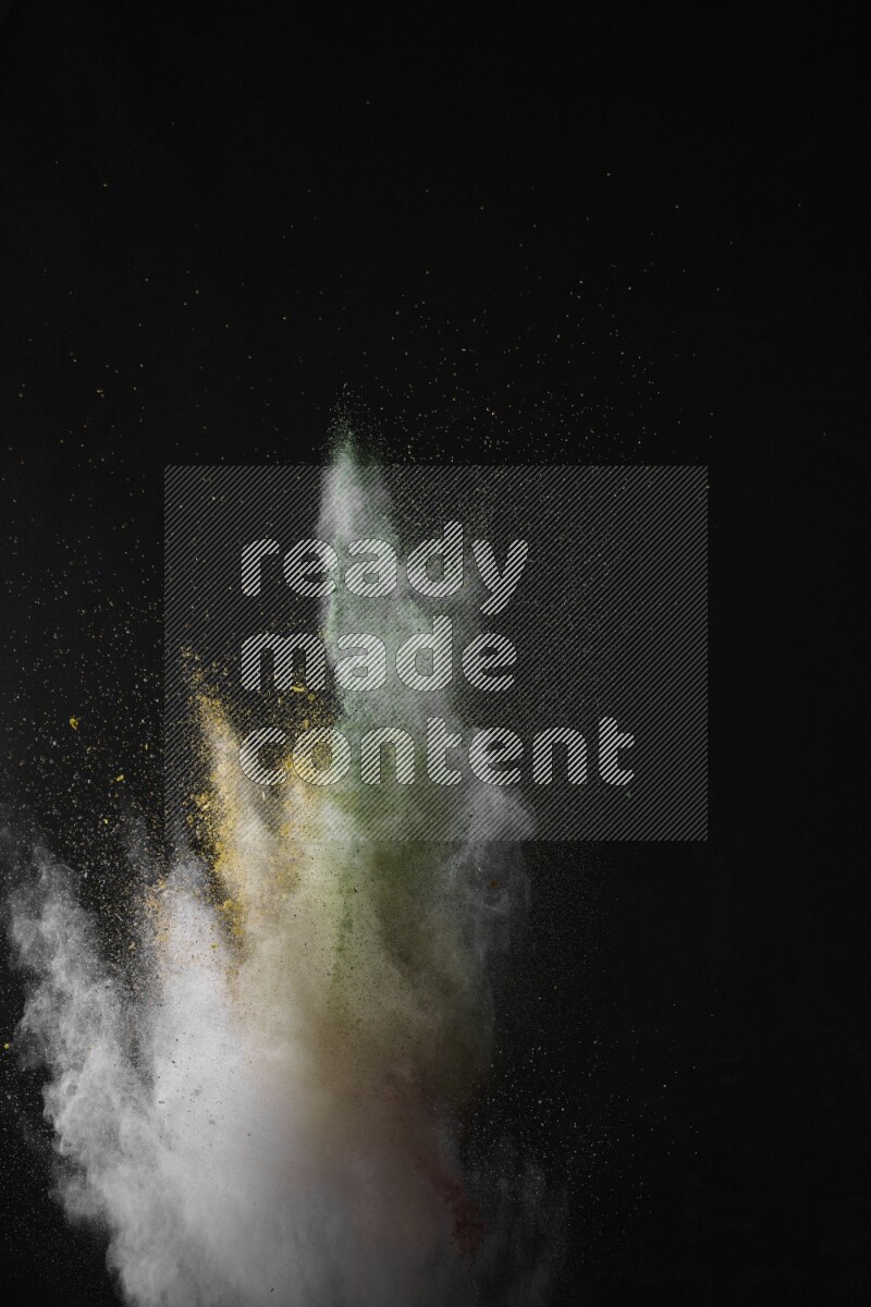 A side view of multicolored powder explosion on black background